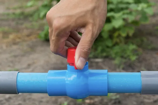 Checking a PVC Valve A technician inspecting a PVC valve in a pipeline for leaks or damage